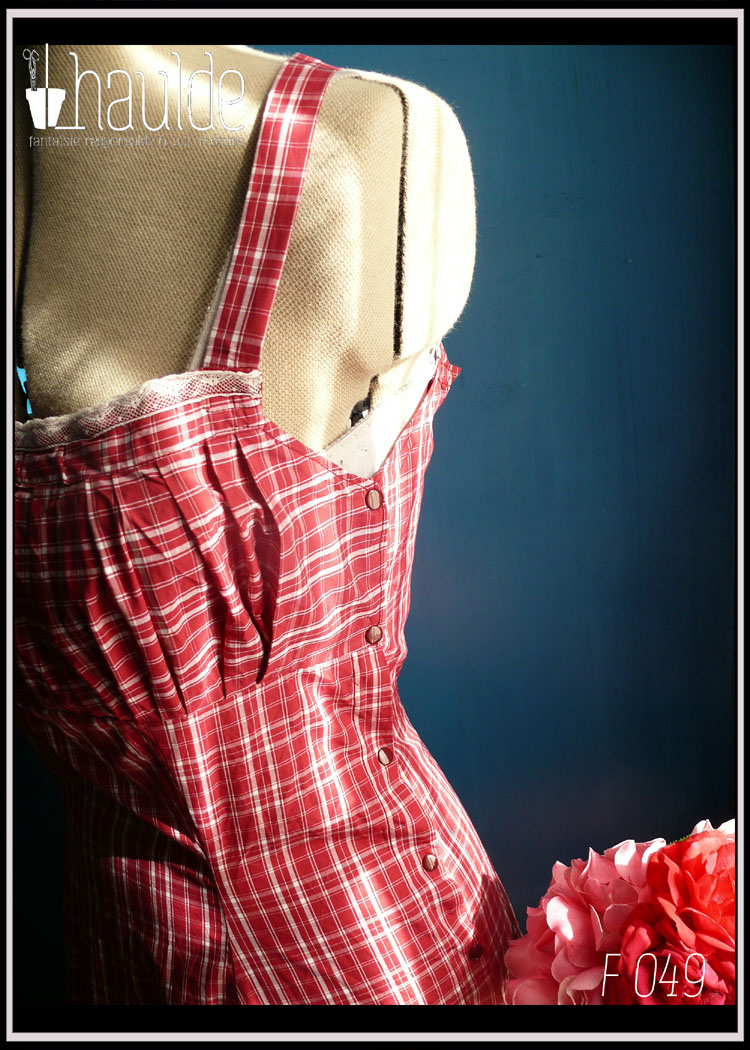 Robe d'été à bretelles croisées dans le dos en batiste légère en écossais rouge bordeaux et blanc avec un ruban de dentelle blanche au niveau du décolleté Vue de trois quarts (boutons pression sous le bras gauche)