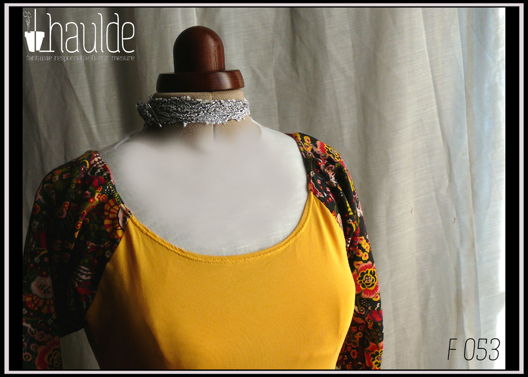 Robe mi-longue en jersey jaune, manches mi-longues raglan en jersey noir imprimé fleurs stylisées jaunes, rouges et roses Grand décolleté rond Vue de détail du buste sur un mannequin couture