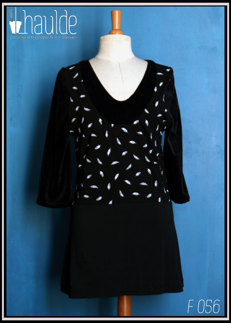 Robe courte à manches longues en jersey noir, jersey noir imprimé plumes blanches au centre en haut devant et dans le dos et velours noir autour de l'encolure en V plongeant Vue en pied sur un mannequin couture