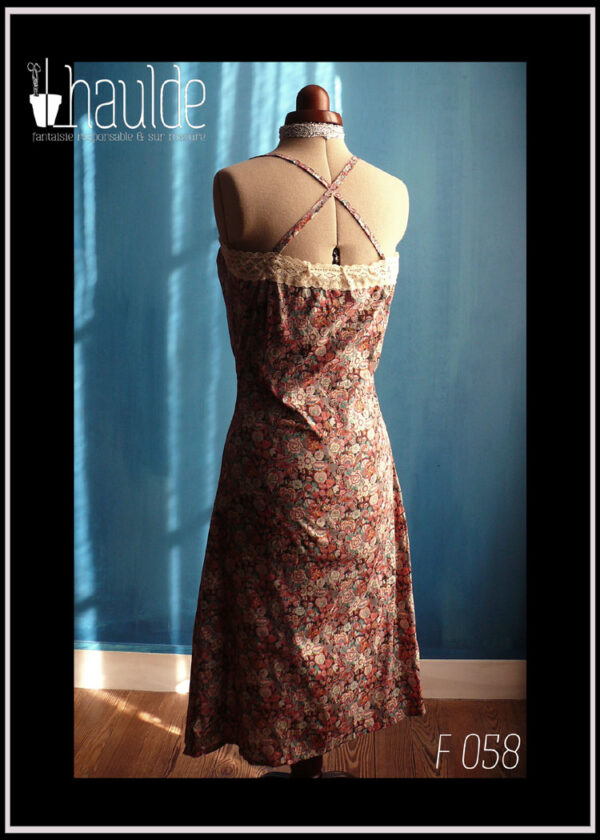 Robe d'été à bretelles croisées dans le dos en liberty ultra léger imprimé fleurs et ruban de dentelle sur tout le tour du haut de la robe. vue en pied de dos
