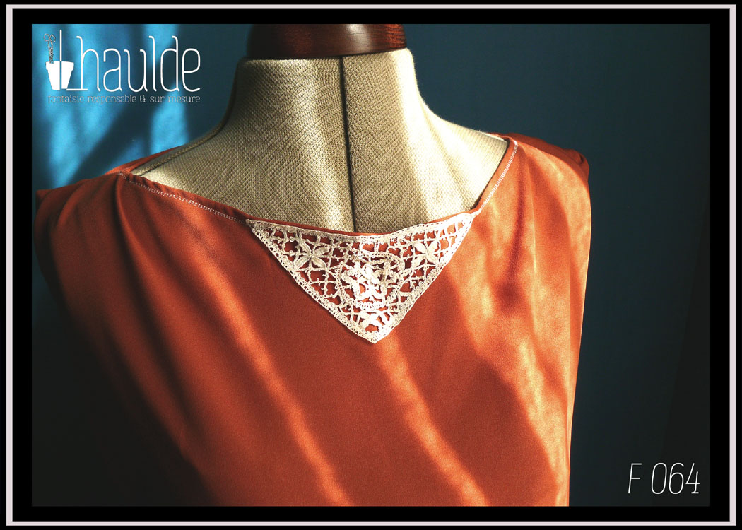 Tunique en crêpe terracotta garnie au niveau de l'encolure d'un triangle de dentelle vintage sur le devant. Ceinture assortie en crêpe recouverte de dentelle rose très pâle Vue de détail de l'encolure devant