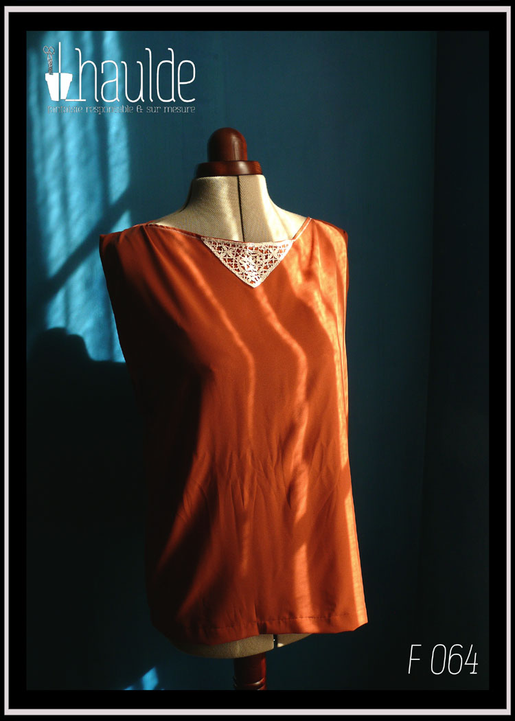 Tunique en crêpe terracotta garnie au niveau de l'encolure d'un triangle de dentelle vintage sur le devant. Ceinture assortie en crêpe recouverte de dentelle rose très pâle Vue de face sur un mannequin couture sans la ceinture au soleil