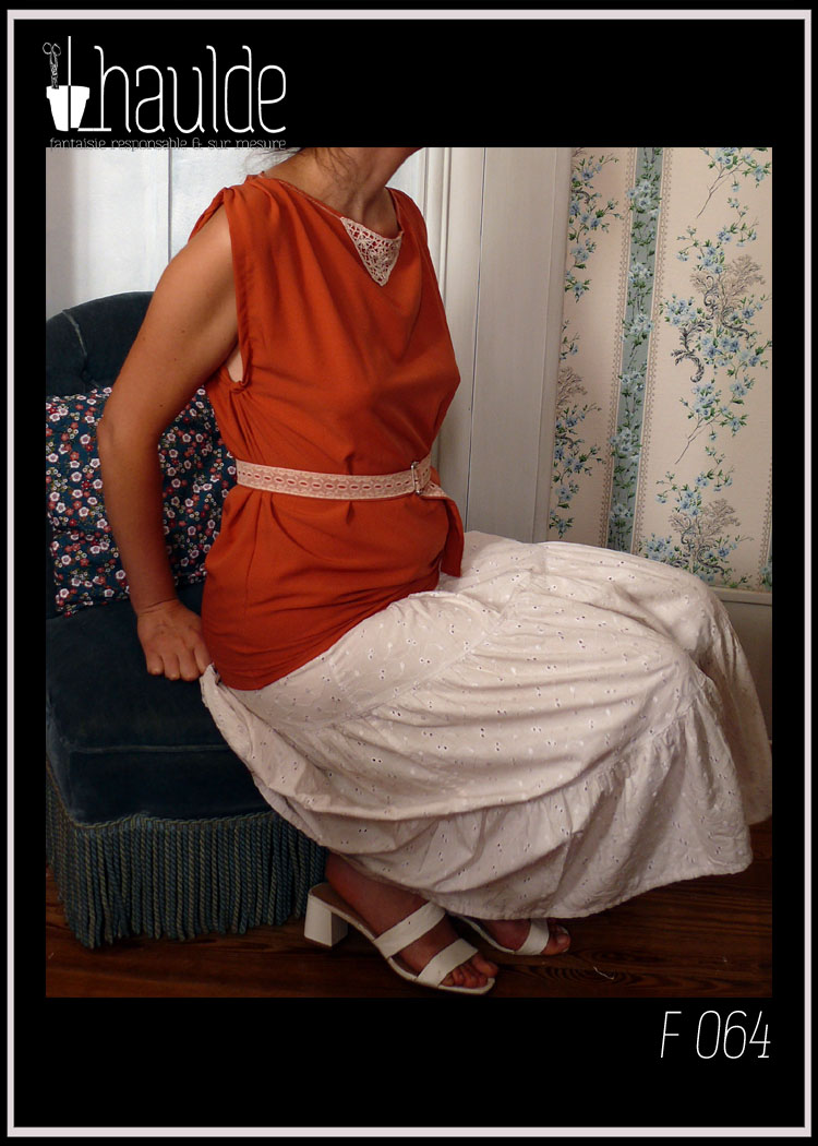 Tunique en crêpe terracotta garnie au niveau de l'encolure d'un triangle de dentelle vintage sur le devant. Ceinture assortie en crêpe recouverte de dentelle rose très pâle Vue portée assise avec la ceinture et un jupon de broderie anglaise blanc