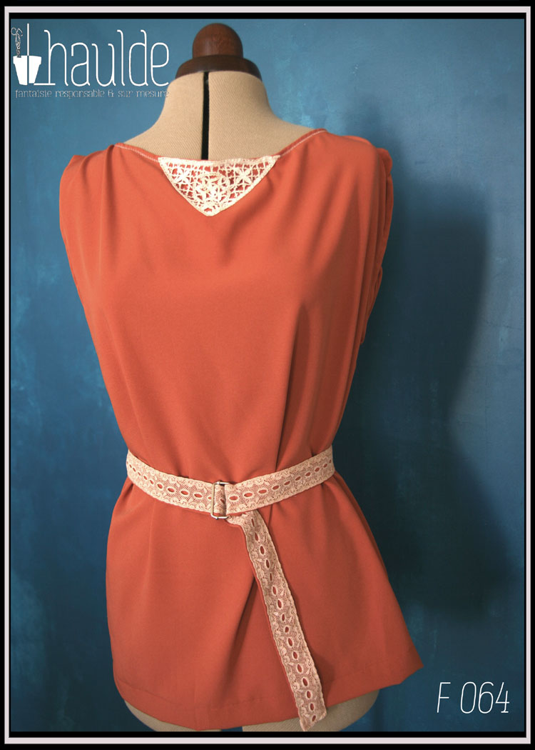 Tunique en crêpe terracotta garnie au niveau de l'encolure d'un triangle de dentelle vintage sur le devant. Ceinture assortie en crêpe recouverte de dentelle rose très pâle Vue de face sur un mannequin couture avec la ceinture