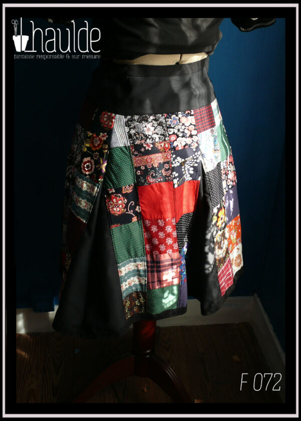 Jupe à pans amples en toile de coton noir couverte de patchwork de tissus variés tant en couleurs qu'en motifs vue de côté