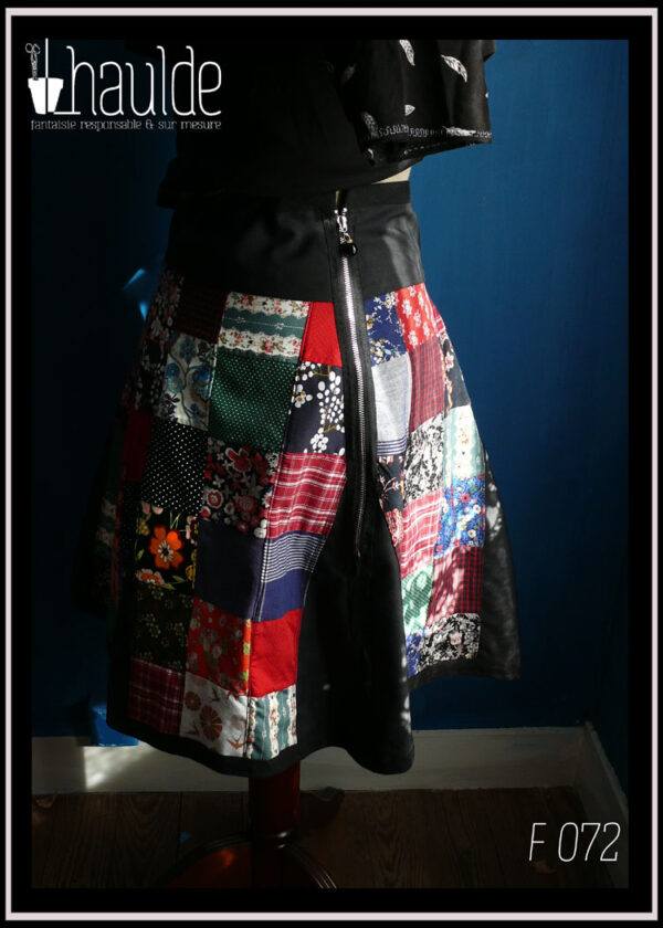 Jupe à pans amples en toile de coton noir couverte de patchwork de tissus variés tant en couleurs qu'en motifs vue de dos