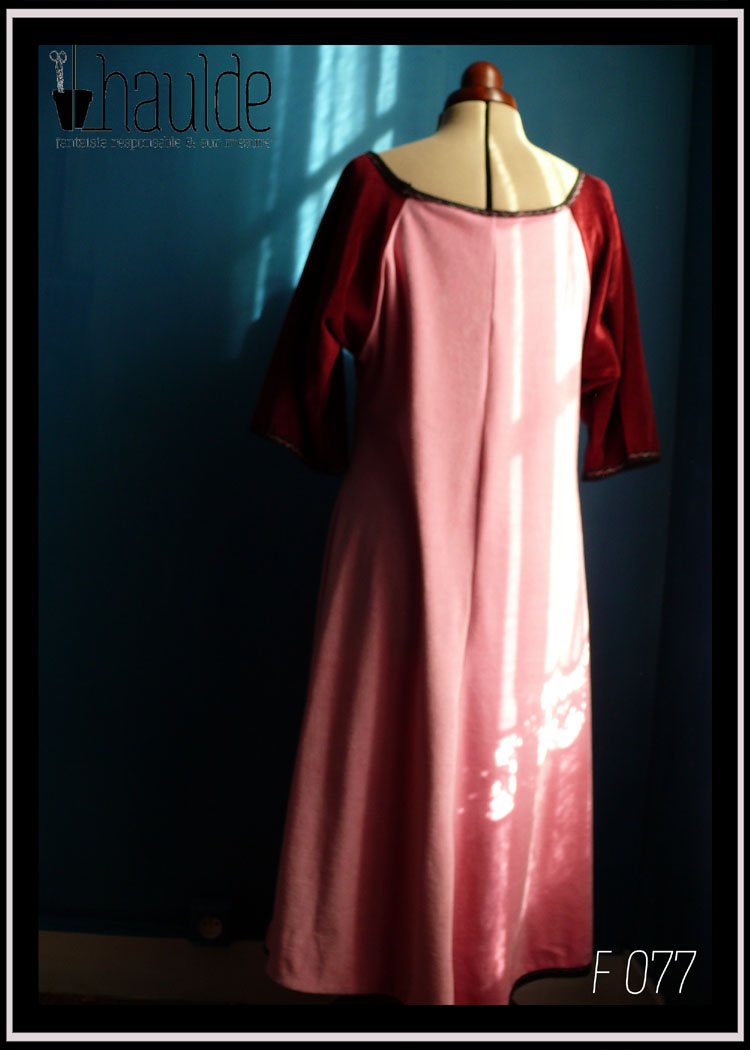 Robe longue à manches raglan mi-longues en velours. Manches en velours rouge bordeaux, reste en velours rose Vue de dos en pied sur un mannequin couture