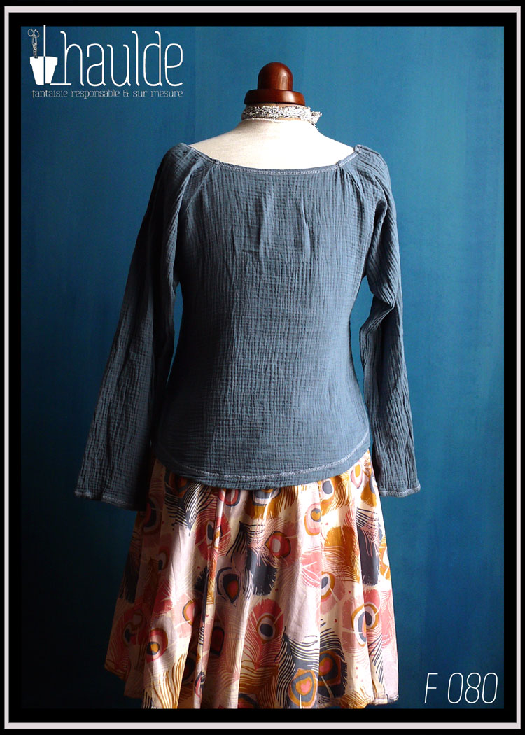 Mannequin couture portant le haut décrit dans la fiche, en double gaze de coton bleu jean avec une bande de dentelle blanche au-dessus du buste. Grande encolure et manches raglan longues Vue de dos en pied