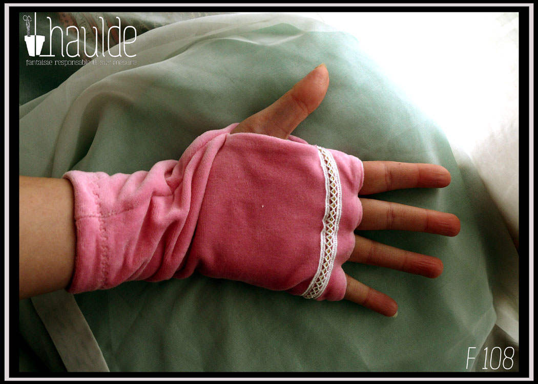 paire de mitaines en velours rose avec un galon de dentelle et une tresse tubulaire en décoration, intérieur en jersey blanc, doigt formés, poignet serré Vue de la paume