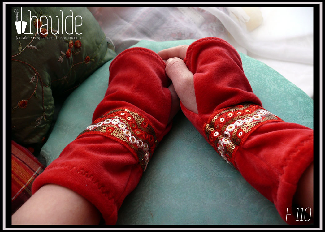 paire de mitaines en velours rouge doublé jersey et garnies d'un galon brodé de sequins Vue de la paire portée