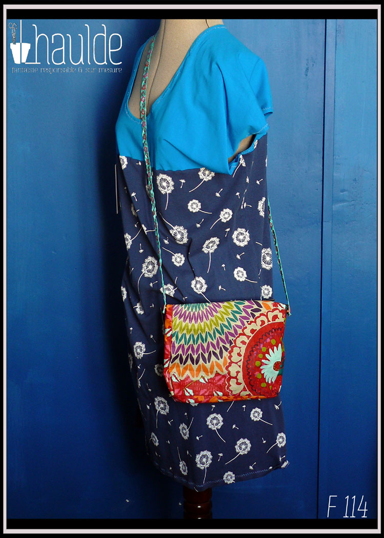 Mini sac zippé en toile enduite imprimé multicolore, doublure synthétique orange foncé Vue d'un côté, porté par un mannequin couture