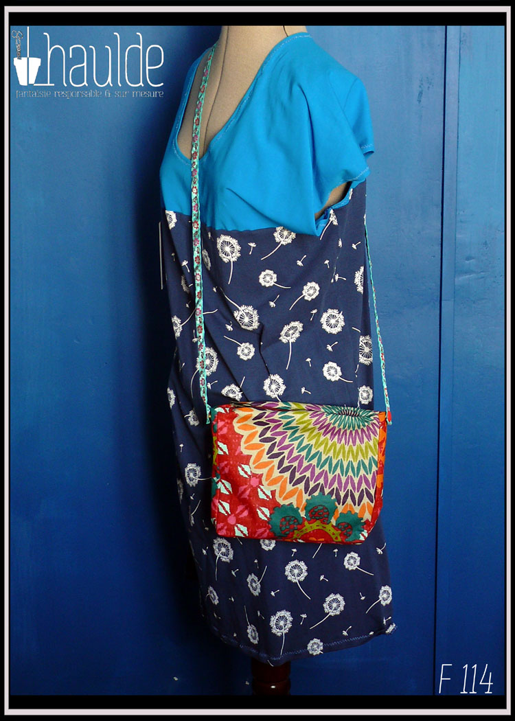 Mini sac zippé en toile enduite imprimé multicolore, doublure synthétique orange foncé Vue d'un côté, porté par un mannequin couture