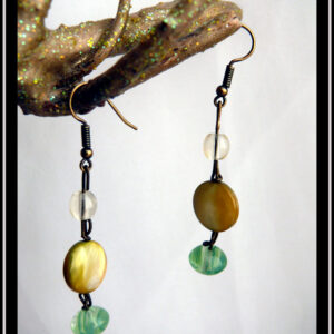 Boucles d'oreilles montées sur crochets d'acier doré, perles alignées à la verticale sur une tige d'acier : petite ronde en verre transparent, perle disque plat en nacre jaune, perle galet en verre vert transparent