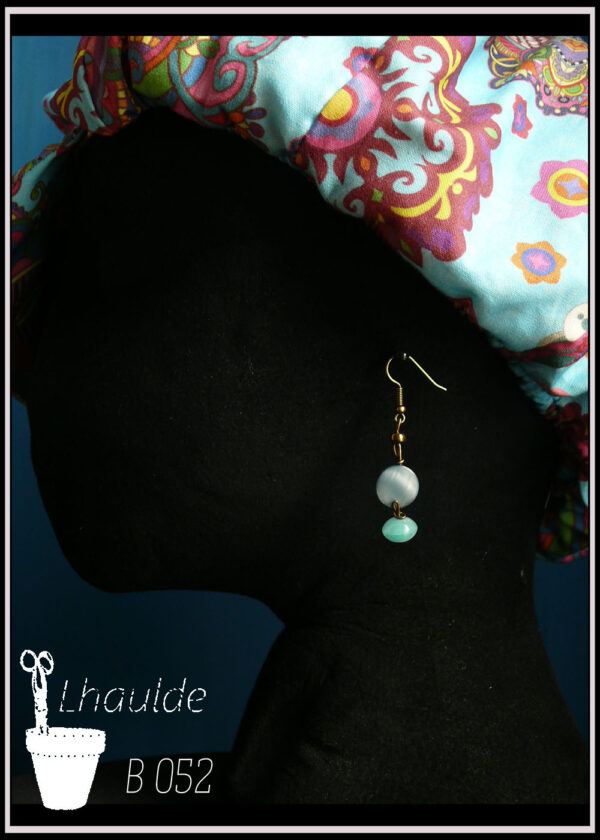 boucles montées sur crochet une perle plate en nacre bleu et une perle galet en verre couleur turquoise Vue de profil sur un mannequin tete