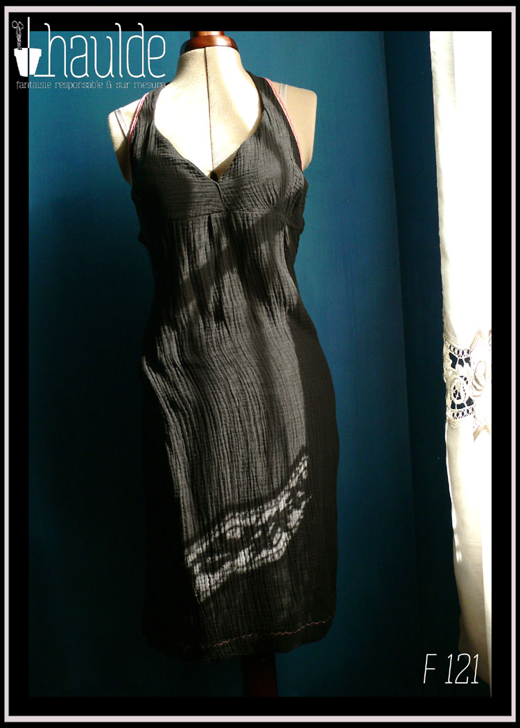 robe dos nu en double gaze noire, décolleté en V plongeant, biais rose le long des emmanchures et attache-cou Vue de face au soleil sur un mannequin de couture