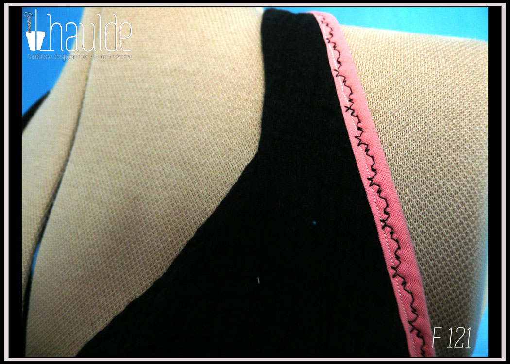 robe dos nu en double gaze noire, décolleté en V plongeant, biais rose le long des emmanchures et attache-cou Vue de détail du buste