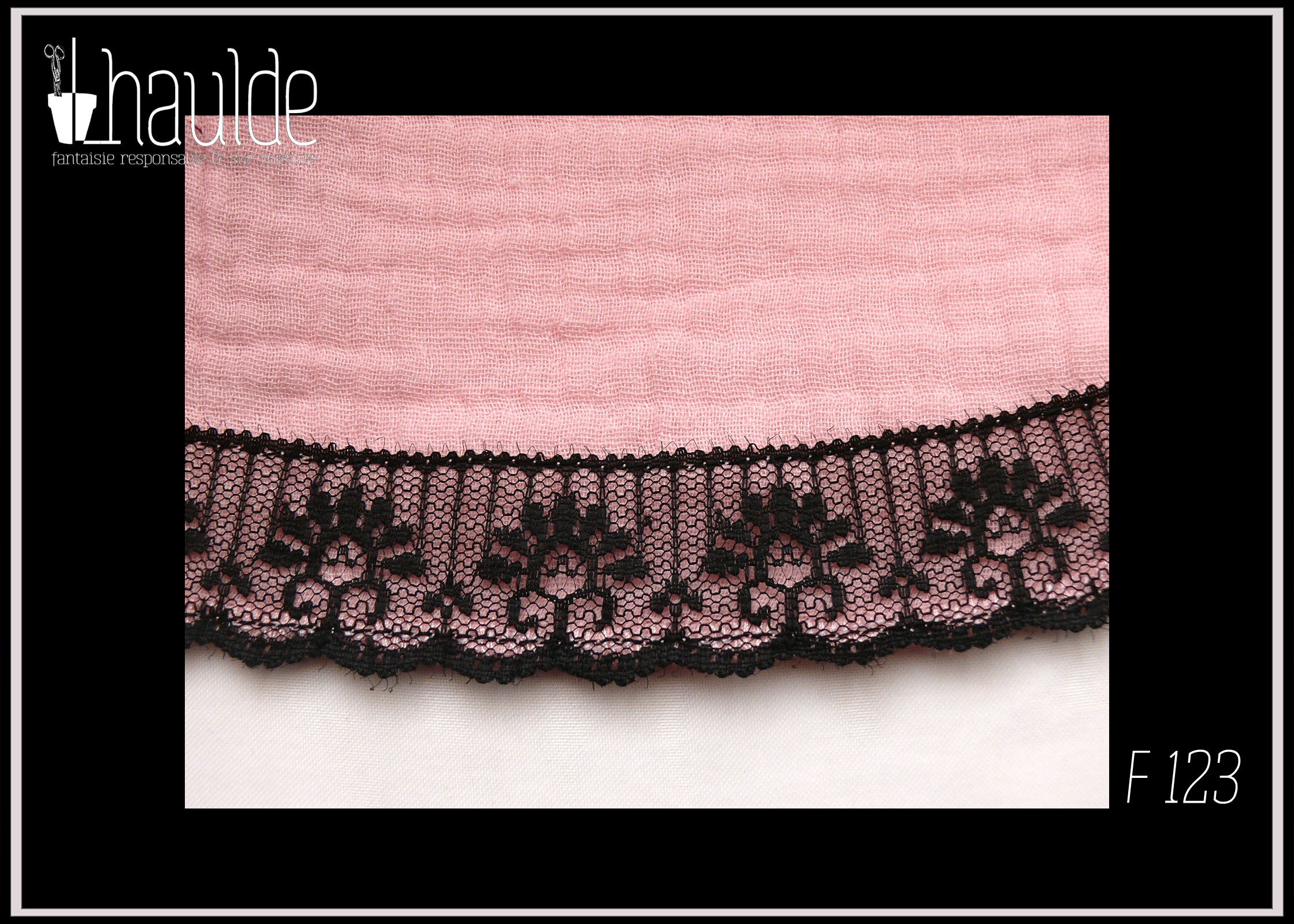 gros plan de la dentelle en bas de la jupe Robe d'été à bretelles en double gaze rose pâle, galon de dentelle noire au bas de la robe, biais noir autour du haut du buste. buste plissé, taille ajustée, jupe évasée.