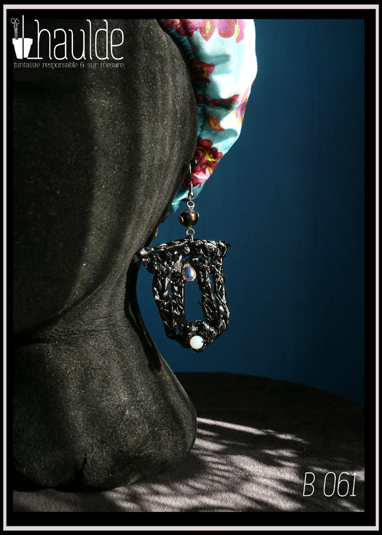 Boucles d'oreilles longues en bande VHS crochetée et garnies de perles bleu pâles iridescentes. Leur forme est un double U fermé en haut. Vues portées sur un mannequin tête