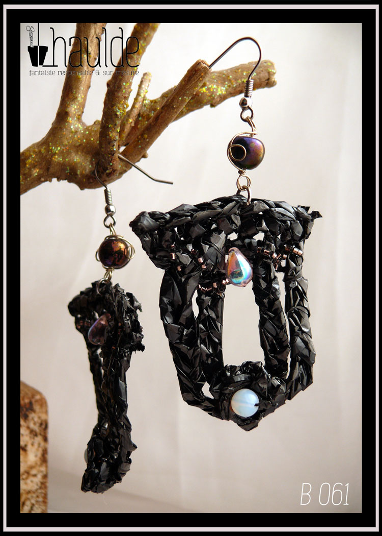 Boucles d'oreilles longues en bande VHS crochetée et garnies de perles bleu pâles iridescentes. Leur forme est un double U fermé en haut.