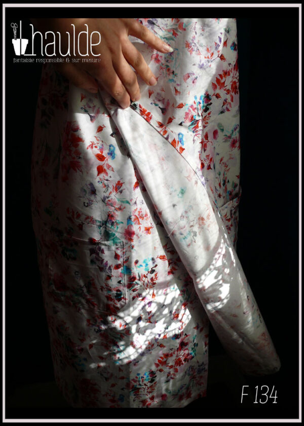 Robe portefeuille sans manche en coton blanc imprimé motifs végétaux et floraux façon aquarelle (rouge mauve bleu et vert) Vue de détail du rabat devant
