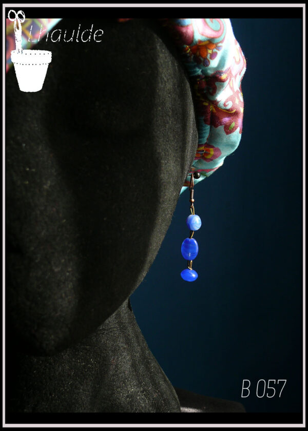 paire de boucles d'oreille, perles en verre bleu outremer monté sur tige d'acier et crochet d'oreille en acier cuivré vue sur un mannequin tete