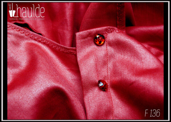 Robe courte dos nu en satin rouge certifié oeko tex, ceinture et poches plaquées en tissu noir à pois blancs Vue de détail des boutons sous le bras gauche