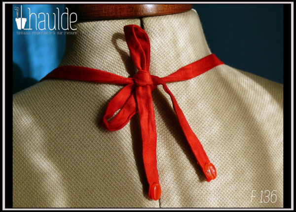 Robe courte dos nu en satin rouge certifié oeko tex, ceinture et poches plaquées en tissu noir à pois blancs Vue de détail du noeud dans le cou