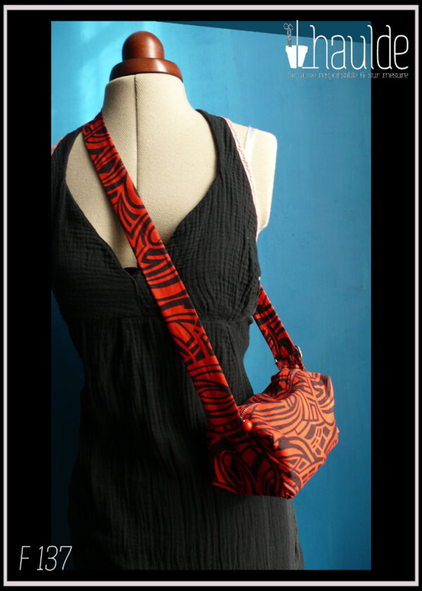 Mini sac en coton rouge imprimé noir (motifs graphiques type zèbre) Vue porté sur un mannequin couture en biais, d'une épaule vers le côté opposé