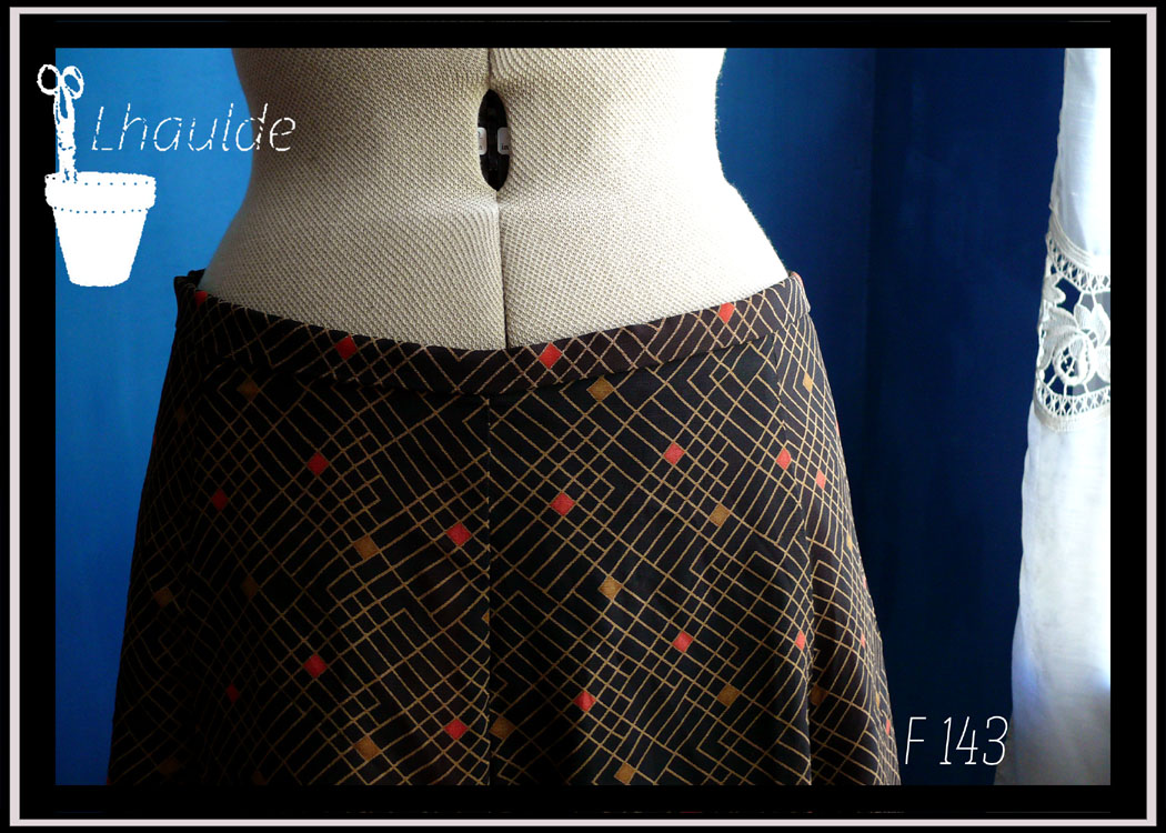 jupe mi longue à pans amples en toile de coton et lin recouverte de voile noir imprimé de motifs géométriques Vue de détail du haut de la jupe