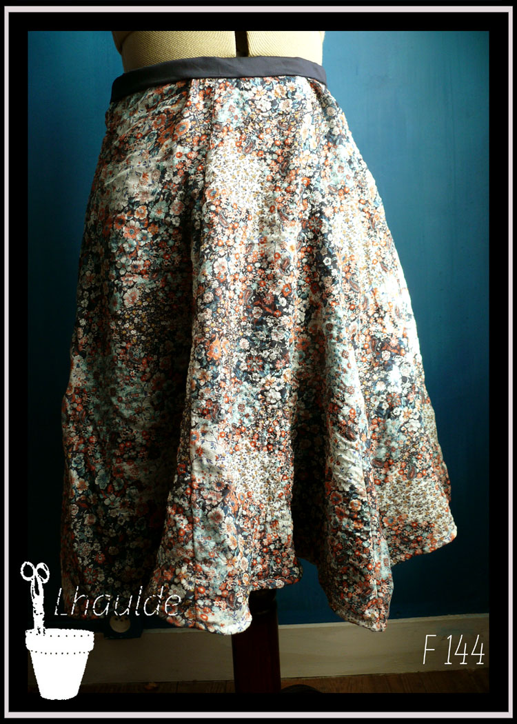 Jupe en satin bleu marine recouvert de voile blanc imprimé fleurs oranges et bleues