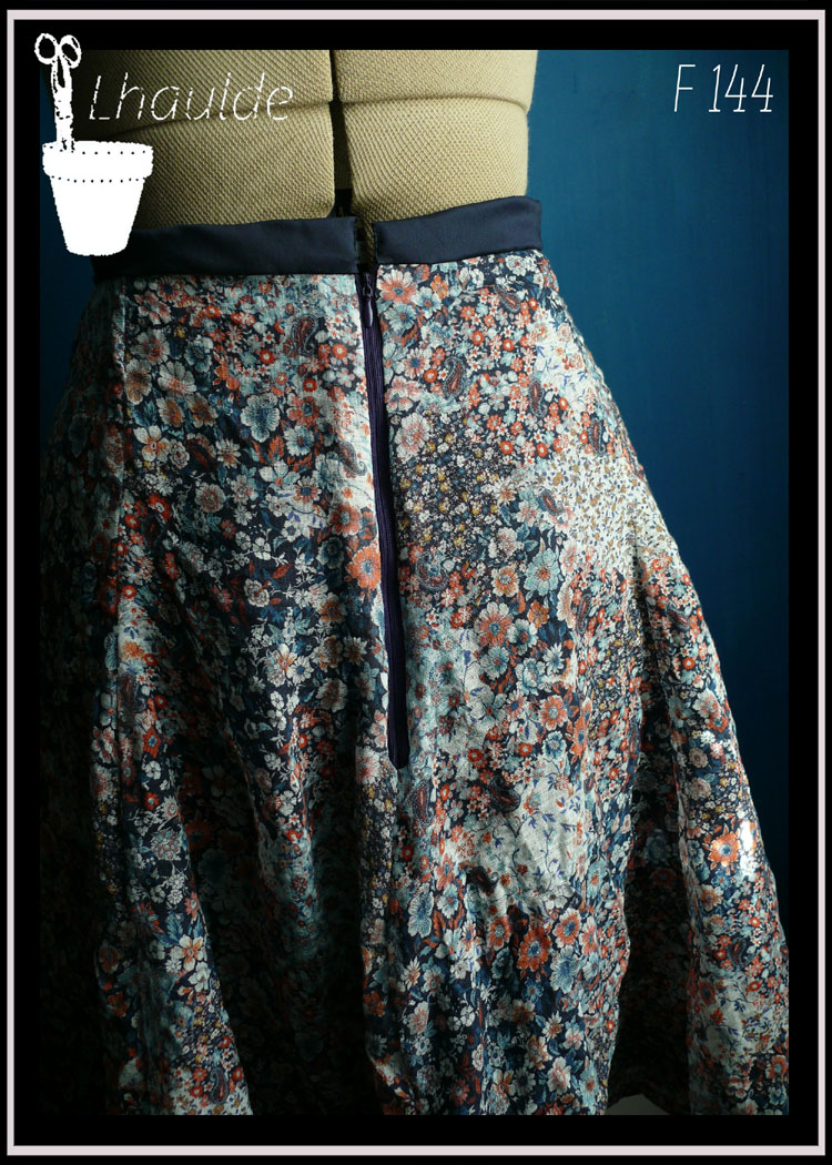 Jupe en satin bleu marine recouvert de voile blanc imprimé fleurs oranges et bleues vue de détail du zip