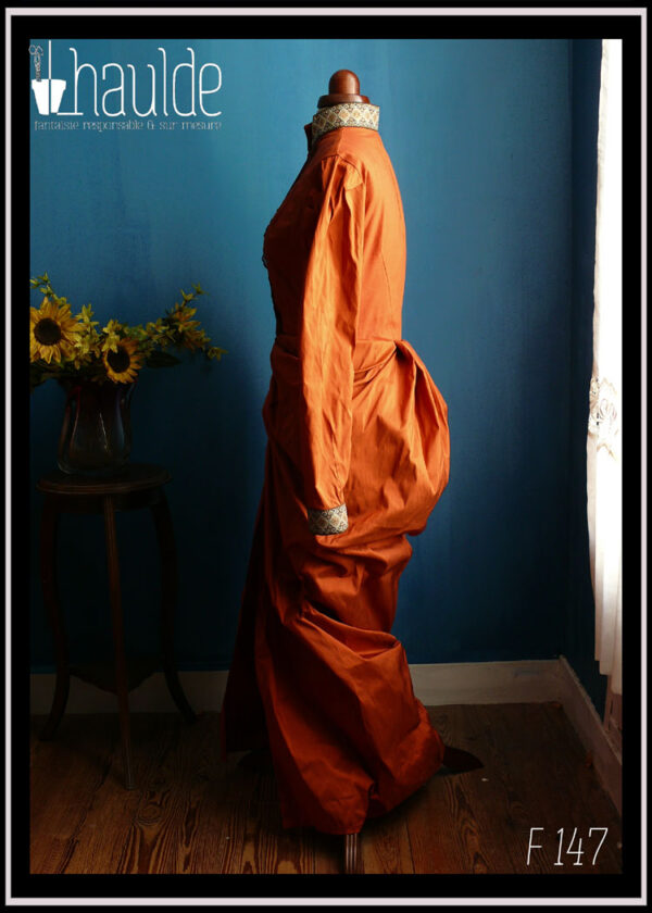 Robe en soie, coupe XIXième, col montant, poitrine ajustée, jupe bouffante sur les reins façon tournure Vue en pied de profil