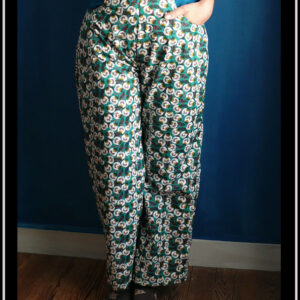 Pantalon en popeline vert émeraude imprimé fleurs stylisées blanches, jambes larges et longues, zip sur le côté gauche, deux grandes poches sur l'avant Vu porté de face