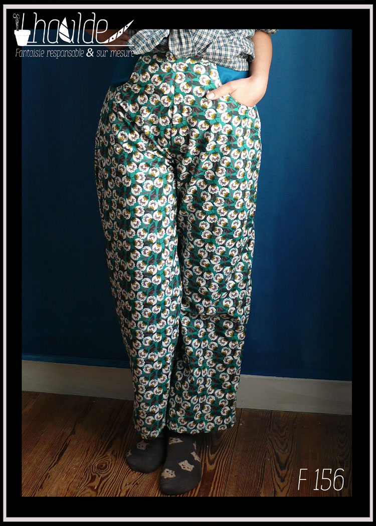 Pantalon en popeline vert émeraude imprimé fleurs stylisées blanches, jambes larges et longues, zip sur le côté gauche, deux grandes poches sur l'avant Vu porté de face