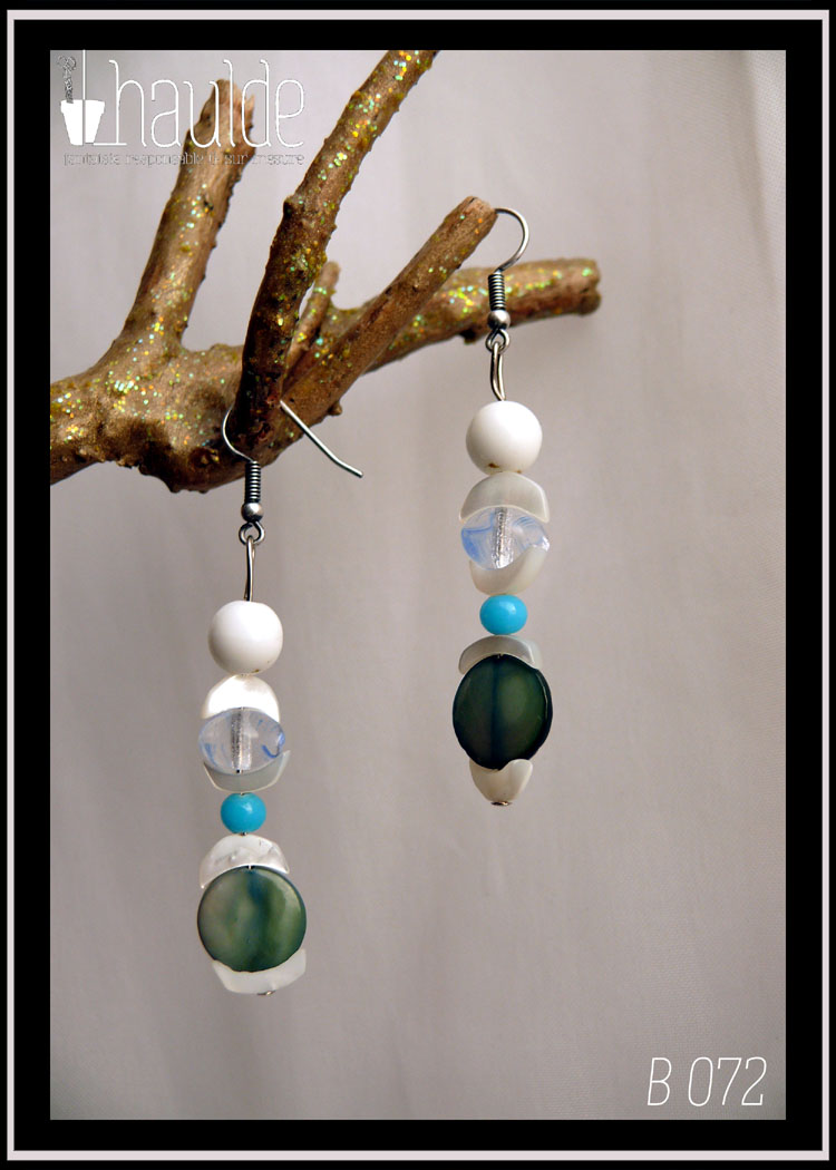 Paire de boucles d'oreilles montée sur crochets acier, perles alignées à la verticale, une ronde verre blanc opaque, une chips de nacre blanc en forme de demi-lune, une perle galet bleu pâle, une chips, une petite ronde bleu ciel, une chips, une perle disque plat en nacre bleue et une chips