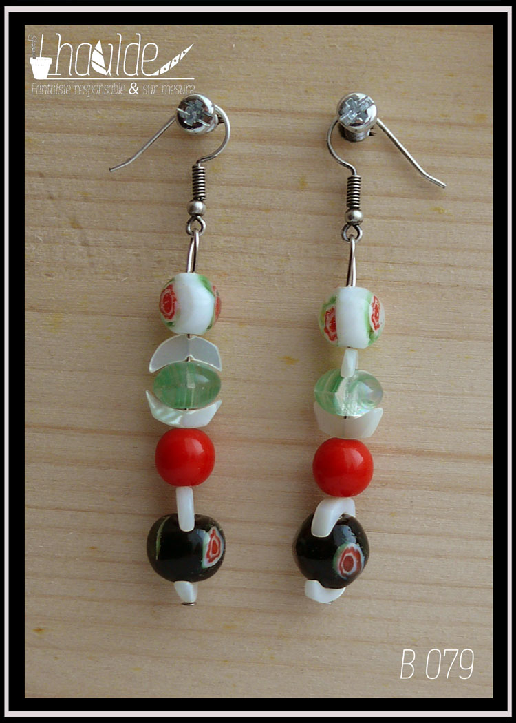Paire de boucles d'oreilles montées sur crochet, de haut en bas alignées à la verticale : une perle en verre blanc incrustation fleur rouge et verre, un chips de nacre en forme de demi-lune, une perle galet en verre vert un autre chips demi lune, une perle rouge, chips, perle noire incrustation fleur rouge et vert, chips.
