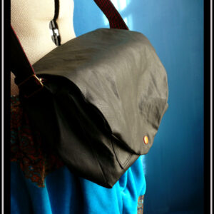 sac en simili cuir noir vu fermé et porté sur un mannequin couture