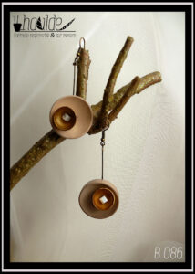 Paire de boucles d'oreilles, crochet acier. Bouton vintage en plastique beige suspendu à une tige en acier couleur bronze avec en son centre une demi-sphère en acier doré qui contient une perle cubique en verre blanc effet nacre. Longueur 6,5 cm