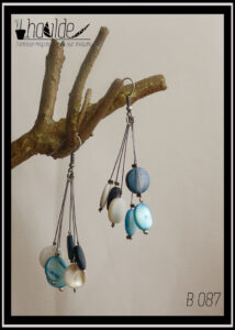 Paire de boucles d'oreilles, crochet acier. Six perles plates en verre imitation nacre, bleu, blanc et bleu foncé chacune au bout d'un fil synthétique rigide. Longueur 6,5 cm