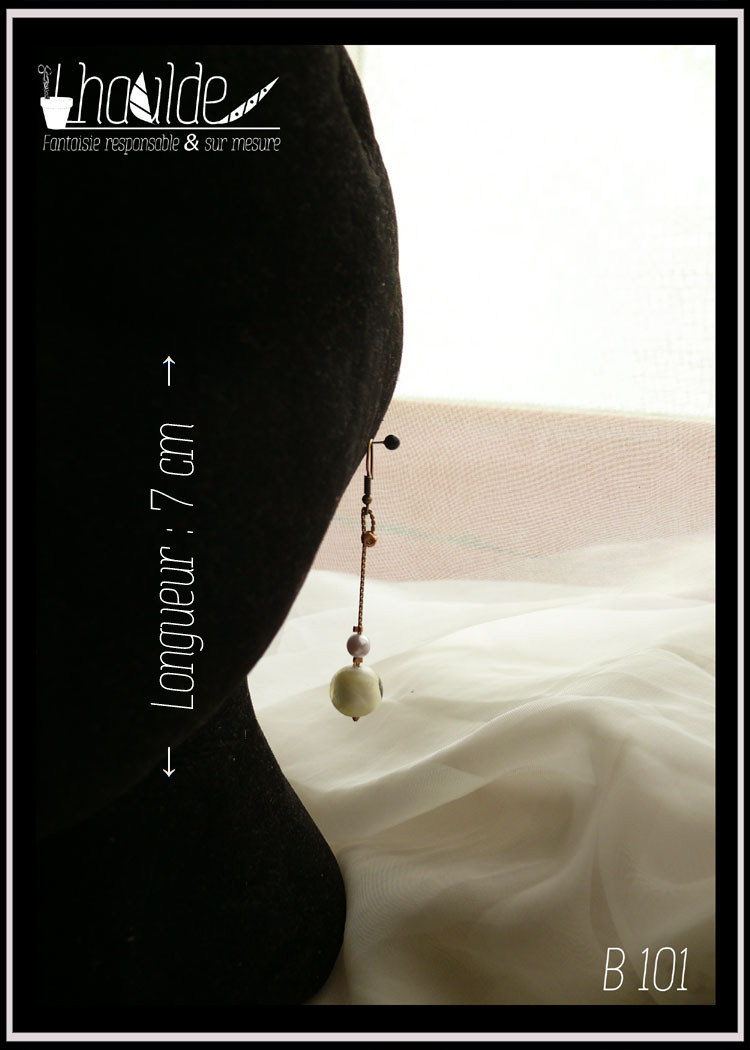 paire de boucles d'oreilles, crochets acier doré, perle en verre au bout d'une chaine tressée en acier doré surmontée d'une petite perle en nacre synthétique légèrement mauve. Longueur 7 cm Vue sur un mannequin tête