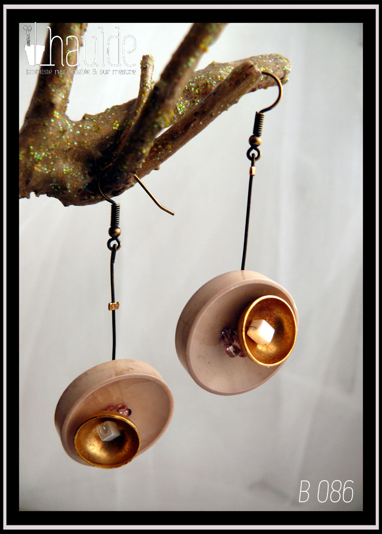 Paire de boucles d'oreilles, crochet acier. Bouton vintage en plastique beige suspendu à une tige en acier couleur bronze avec en son centre une demi-sphère en acier doré qui contient une perle cubique en verre blanc effet nacre. Longueur 6,5 cm