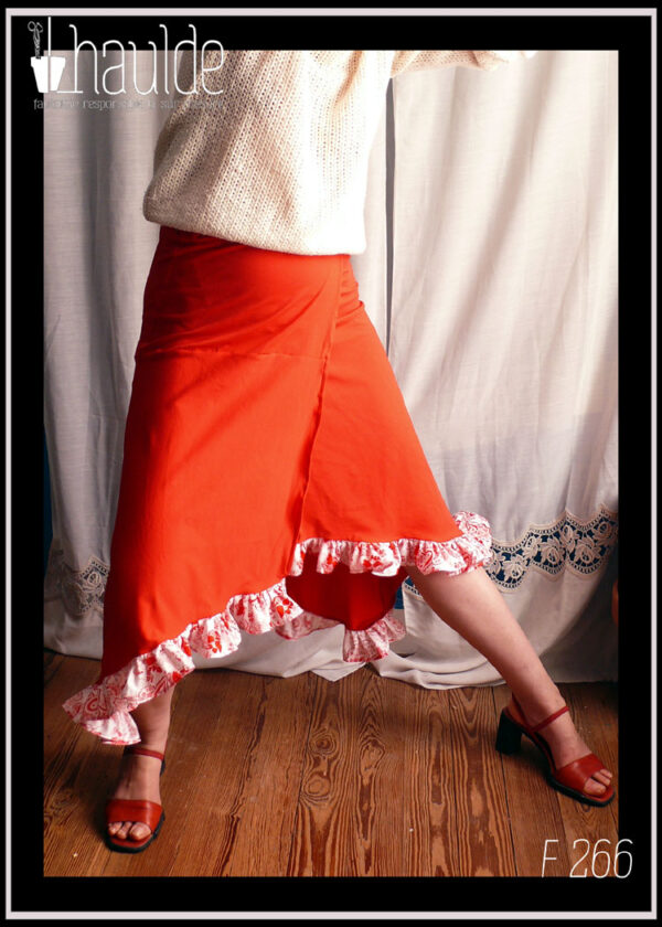 jupe portefeuille asymétrique en jersey rouge à volants de popeline blanche imprimée fleurs rouges Vue portée, les jambes formant un grand angle pour voir comment la jupe se rabat