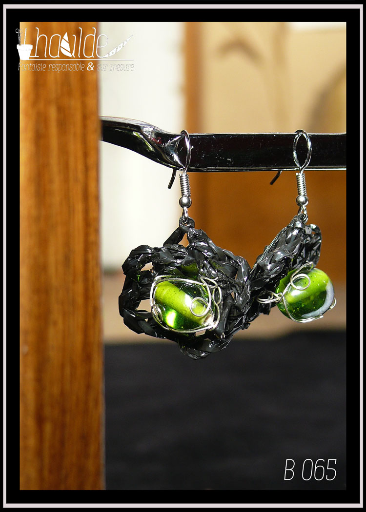 paire de boucles d'oreilles en VHS crochetée montée sur crochet d'acier. Vidéo crochetée de forme ovale avec en son centre une grosse perle en verre vert. Vue de la paire, de face