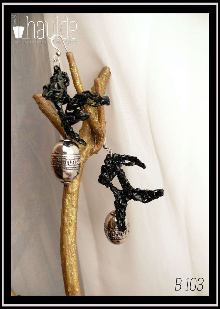 paire de boucles d'oreilles montées sur crochet acier. VHS crochetée en forme de feuilles longues avec pendant. Le pendant est un gland argenté