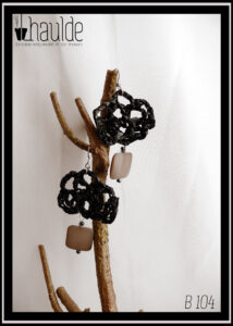 Paire de boucles d'oreilles montées sur crochet acier. Bande vidéo crochetée façon dentelle avec un pendant perle carrée beige nacrée