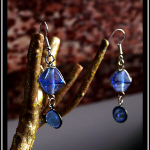 Paire de boucles d'oreilles montées sur crochet acier. Perles en verre bleu, reliées par de petits anneaux en acier. En haut polyèdre entouré de boucles d'acier, en-dessous demi-boule sertie