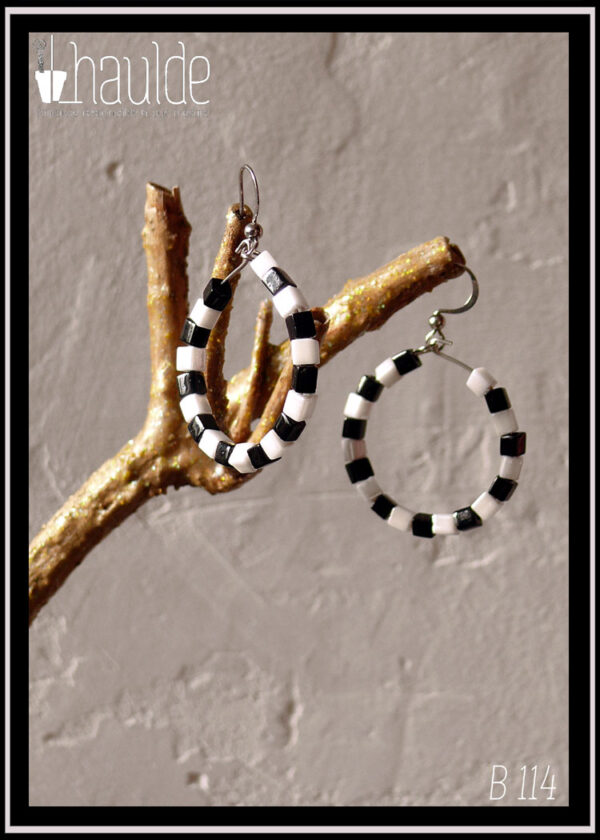 Paire de boucles d'oreilles montées sur créoles et crochet d'acier. La créole est garnie de perles cubiques noires et blanches alternées