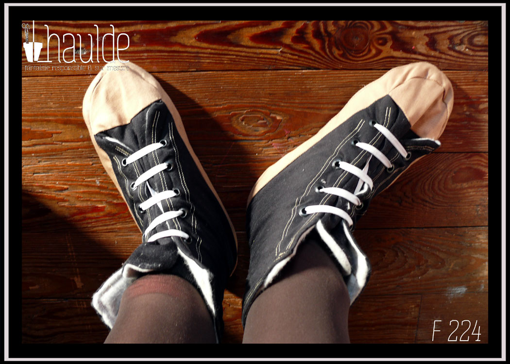 Vue de dessus, portés Paire de chaussons façon converse, bout et bande inférieure beige, haut du pied et semelle noirs. Lacets élastiques blancs