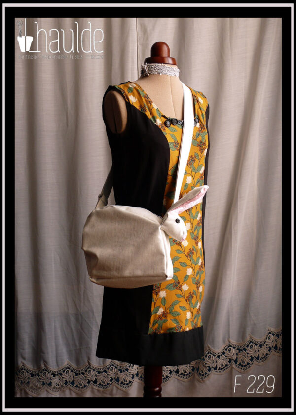 Sac blanc en forme de lapin (tête à l'avant du sac dans le prolongement) Vu sur l'épaule d'un mannequin couture de profil