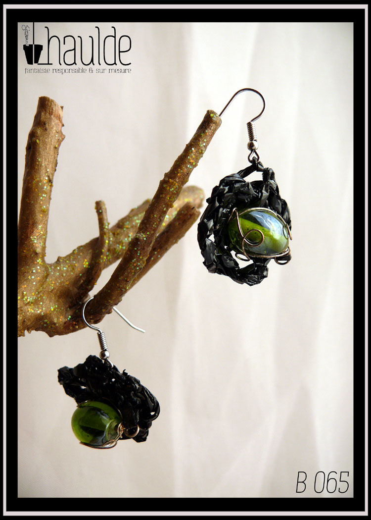 paire de boucles d'oreilles en VHS crochetée montée sur crochet d'acier. Vidéo crochetée de forme ovale avec en son centre une grosse perle en verre vert.